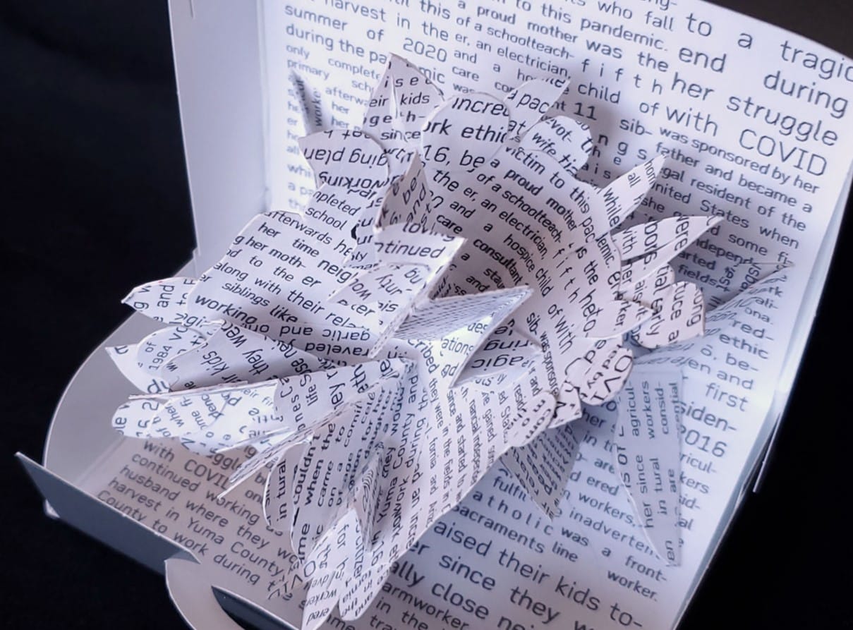 Close up of cut up paper with text from news about someone who died from Covid -19.