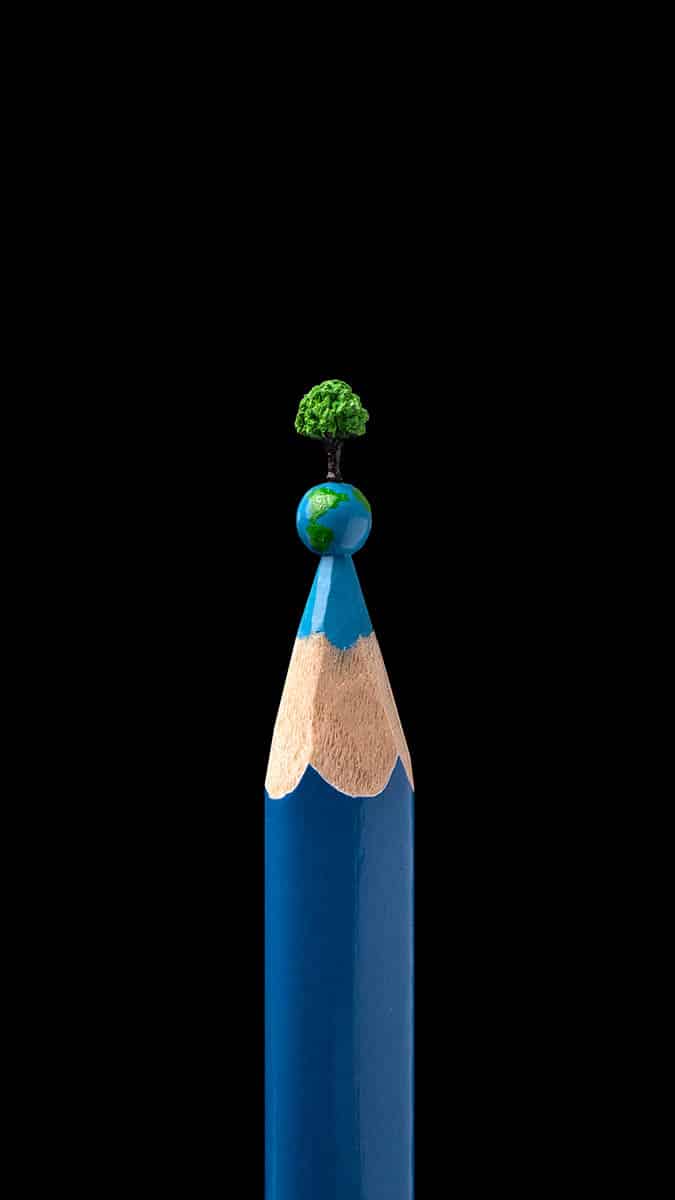 Micro-sculpture of tree on top of earth on the tip of a pencil.